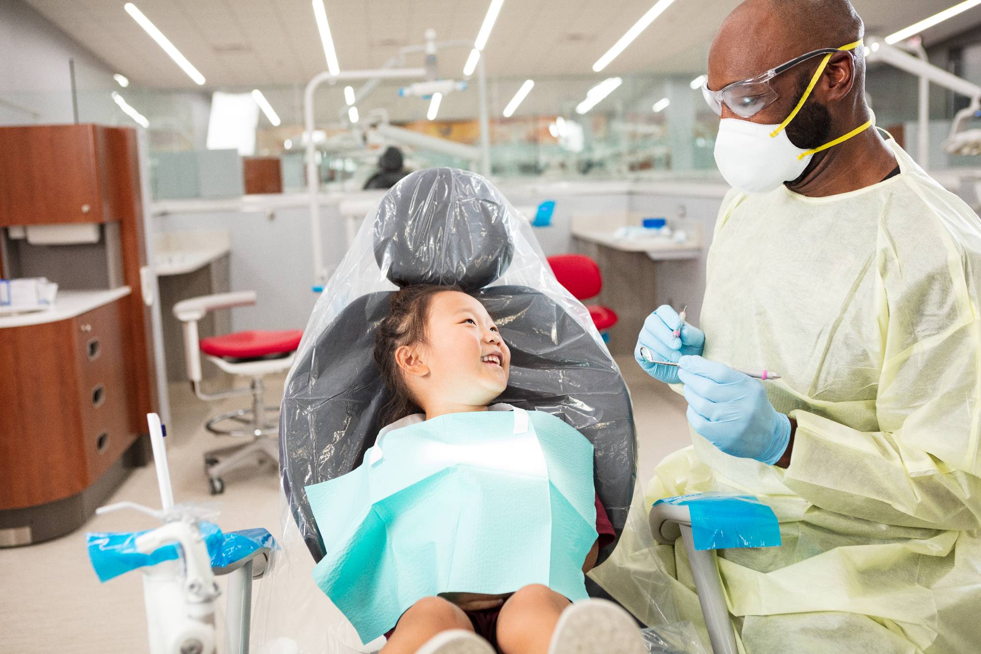 Child patient in chair with Dental student sitting across.